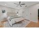 Comfortable main bedroom featuring hardwood floors, ceiling fan and bench seating at 4805 E Regnas Ave, Tampa, FL 33617
