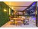 Outdoor dining area with a TV, greenery, pool view, and overhead lighting for a cozy atmosphere at 4805 E Regnas Ave, Tampa, FL 33617
