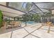 Elegant outdoor patio with an expansive seating area, dining space, and pool, perfect for entertaining or relaxation at 4805 E Regnas Ave, Tampa, FL 33617