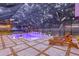 Relaxing pool area at dusk with colorful lighting, screened enclosure, and outdoor seating, perfect for evening relaxation and fun at 4805 E Regnas Ave, Tampa, FL 33617