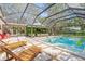 Luxurious screened-in pool area with comfortable lounge chairs, offering a perfect escape for relaxation and recreation at 4805 E Regnas Ave, Tampa, FL 33617