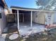 Backyard view of a detached shed with a partial roofed area and paint cans on the concrete at 4812 Bonita Vista Dr, Tampa, FL 33634