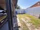 View of a fenced backyard with grass and a pathway to a gated entrance on a sunny day at 4812 Bonita Vista Dr, Tampa, FL 33634