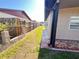 Long side yard view showing a brick tiled area along the house and a wood fence in the distance at 4812 Bonita Vista Dr, Tampa, FL 33634