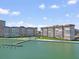 Wide aerial view showcases waterfront condominium buildings with dock, lush landscaping and waterfront at 5130 Brittany S Dr # 604, St Petersburg, FL 33715