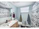 Cozy bathroom featuring a vanity with modern black faucet, a shower with charming nautical themed curtains, and a window at 5130 Brittany S Dr # 604, St Petersburg, FL 33715