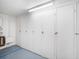 This storage area features multiple white storage lockers with metal latches and blue painted floors at 5130 Brittany S Dr # 604, St Petersburg, FL 33715