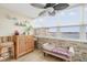 Bright sunroom with water views, wicker cabinet, ceiling fan, and stone accent wall at 5130 Brittany S Dr # 604, St Petersburg, FL 33715