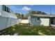 View of the backyard area with partial fence, grass, small trees and access to the home at 5340 Denver Ne St, St Petersburg, FL 33703
