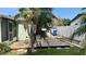 Backyard view of deck, palm trees, with view of the green space and fenced yard at 5340 Denver Ne St, St Petersburg, FL 33703