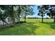 View from grassy backyard overlooking community park space and mature trees on a sunny day at 5340 Denver Ne St, St Petersburg, FL 33703