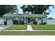 Charming single-story home with well-manicured lawn, mature trees, and sidewalk to the front door at 5340 Denver Ne St, St Petersburg, FL 33703