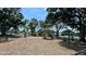 Community playground with swings and slides shaded by mature trees in a green space at 5340 Denver Ne St, St Petersburg, FL 33703