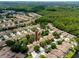Aerial view of a townhouse community with lush landscaping and a nearby wooded area at 5524 Salem Square N Dr, Palm Harbor, FL 34685