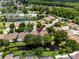 Aerial view of a residential community with mature trees, single-story homes, and ponds at 5524 Salem Square N Dr, Palm Harbor, FL 34685
