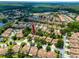 Expansive aerial view of a well-planned community with villas, lush landscaping, and ponds at 5524 Salem Square N Dr, Palm Harbor, FL 34685