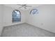 Empty bedroom with neutral carpet, ceiling fan, and arched windows at 5524 Salem Square N Dr, Palm Harbor, FL 34685