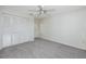 Carpeted bedroom with ceiling fan, closet and white walls at 5524 Salem Square N Dr, Palm Harbor, FL 34685