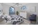 Bright bedroom featuring arched windows, ceiling fan, carpet floors and blue and white patterned bedding at 5524 Salem Square N Dr, Palm Harbor, FL 34685