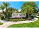 Landscaped entrance sign for Salem Square, featuring lush greenery and mature palm trees at 5524 Salem Square N Dr, Palm Harbor, FL 34685