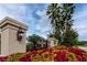 Close-up of community entrance sign with a wrought iron gate and colorful flowerbed at 5524 Salem Square N Dr, Palm Harbor, FL 34685