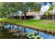 Charming single-story villa with screened lanai overlooking a serene pond with lush lily pads at 5524 Salem Square N Dr, Palm Harbor, FL 34685