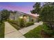 Well-maintained home with walkway and attached garage under a beautiful sunset at 5524 Salem Square N Dr, Palm Harbor, FL 34685