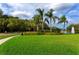 Landscaped green space with palm trees, manicured bushes and a tranquil lake with a fountain at 5524 Salem Square N Dr, Palm Harbor, FL 34685