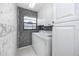Cozy laundry room with a modern washer and dryer, storage cabinets, and unique wallpaper at 5524 Salem Square N Dr, Palm Harbor, FL 34685