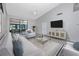 Bright living room featuring modern furniture, a ceiling fan, and sliding glass doors to the patio at 5524 Salem Square N Dr, Palm Harbor, FL 34685