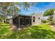 Rear view of a charming home with a screened sunroom addition at 5524 Salem Square N Dr, Palm Harbor, FL 34685