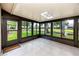 Spacious sunroom featuring tile flooring and a beautiful view of the pond and mature trees at 5524 Salem Square N Dr, Palm Harbor, FL 34685