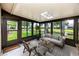 Inviting sunroom with tile flooring, pond view, and comfortable seating arrangement at 5524 Salem Square N Dr, Palm Harbor, FL 34685
