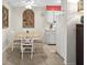 Dining area next to kitchen with white table and chairs, tile floors, and warm lighting at 600 71St Ave # 18, St Pete Beach, FL 33706