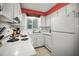 Bright kitchen features white cabinets, tile countertops, and essential appliances at 600 71St Ave # 18, St Pete Beach, FL 33706