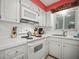 Bright kitchen features white cabinets, tile countertops, and essential appliances at 600 71St Ave # 18, St Pete Beach, FL 33706