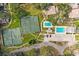 Aerial view of a tennis court, two swimming pools, and a parking lot and driveways at 6206 Dewdrop Way # 0, Temple Terrace, FL 33617