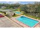 Aerial view showcasing a pool, parking lot, tennis court, and clubhouse in a community setting at 6206 Dewdrop Way # 0, Temple Terrace, FL 33617