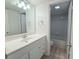 Bright bathroom with a large mirror over the vanity and an open doorway to the shower and toilet at 6206 Dewdrop Way # 0, Temple Terrace, FL 33617