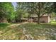 Exterior view of a large backyard and home with mature landscaping and a wood fence at 6406 Congress St, New Port Richey, FL 34653