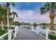 Scenic view of a gray wooden bridge with white railings over a tranquil lake with palm trees at 6406 Congress St, New Port Richey, FL 34653