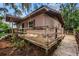 Exterior showcasing ramp access to a charming stucco home with a covered porch, blending accessibility with curb appeal at 6406 Congress St, New Port Richey, FL 34653