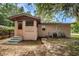 Exterior view of a tan home with a small porch with green steps, chain link fence, and mature landscaping at 6406 Congress St, New Port Richey, FL 34653