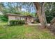 A cozy single-story property featuring a wooden porch and lush greenery at 6406 Congress St, New Port Richey, FL 34653