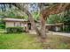 Single-story home featuring a cozy porch and shaded by mature trees at 6406 Congress St, New Port Richey, FL 34653