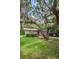 View of the home with a quaint porch surrounded by moss-draped trees at 6406 Congress St, New Port Richey, FL 34653