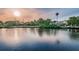 Gorgeous waterfront homes reflected in water under a golden sky with palm trees at 6406 Congress St, New Port Richey, FL 34653