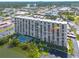 Scenic view of the condo building, pool, and water with mature trees surrounding at 7050 Sunset S Dr # 1401, South Pasadena, FL 33707