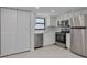 The kitchen features stainless steel appliances, white cabinets, and modern finishes at 7050 Sunset S Dr # 1401, South Pasadena, FL 33707