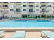 Community pool with lounge chairs at 7050 Sunset S Dr # 1401, South Pasadena, FL 33707